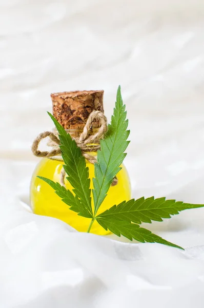 Олія конопель і листя марихуани на білому — стокове фото