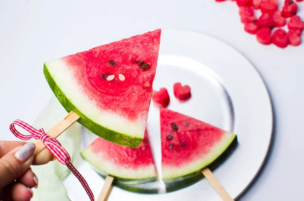 Kvinna som håller en vattenmelon frukt skiva på en pinne — Stockfoto