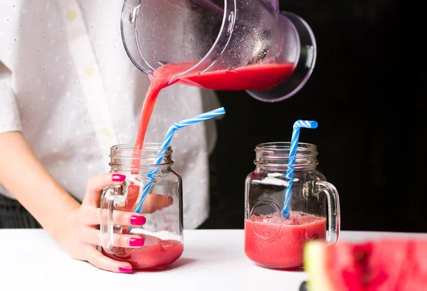 Feminino derramando smoothie melancia em um frasco — Fotografia de Stock