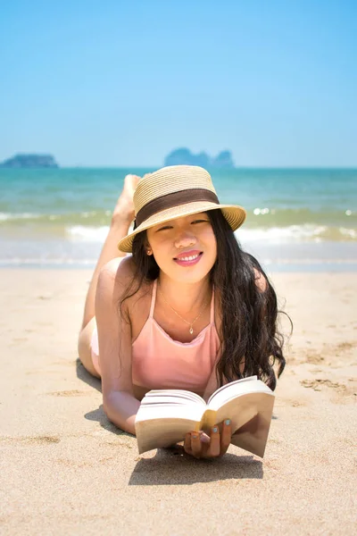 Menina leitura livro e banhos de sol na praia — Fotografia de Stock