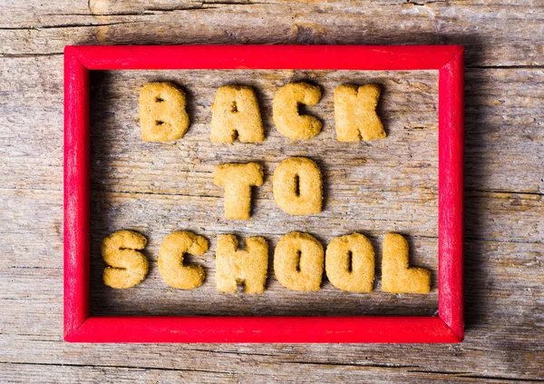 Torna a scuola scritto con i biscotti sul tavolo di legno — Foto Stock