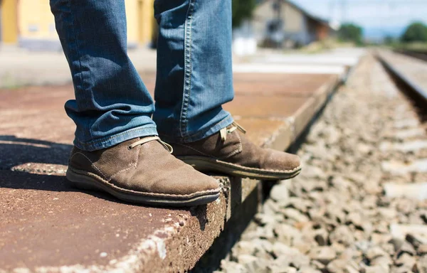 Чоловік чекає на поїзд у старовинному взутті — стокове фото