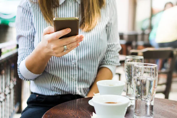 Flicka med telefon i kaffebaren — Stockfoto