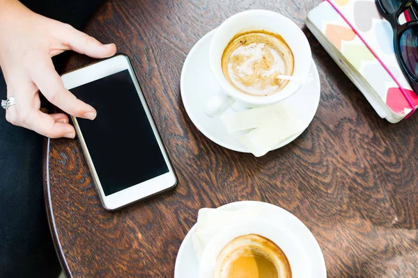 Flicka med telefon i kaffebaren — Stockfoto