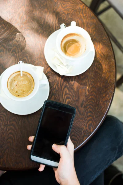 Flicka med telefon i kaffebaren — Stockfoto