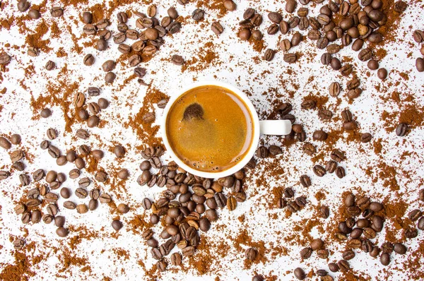 Tasse Kaffee mit Körnern und Pulver auf weiß — Stockfoto