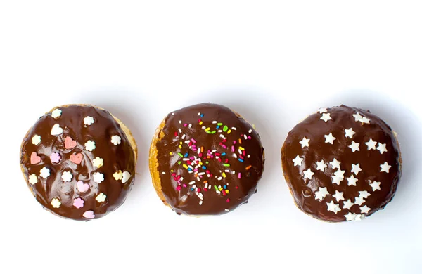 Прикрашені шоколадні пончики на білому тлі — стокове фото