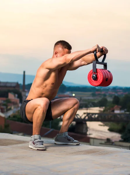 Men performing squats with shoulder raise on the rooftop — Stock Photo, Image