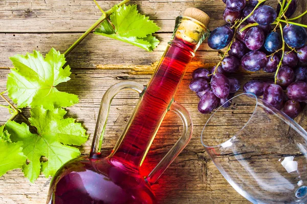 Red wine with grape on rustic wooden background — Stock Photo, Image