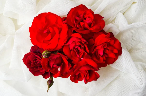 Buquê de rosas vermelhas em tecido branco — Fotografia de Stock