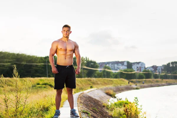 Maskulin man står vid floden — Stockfoto