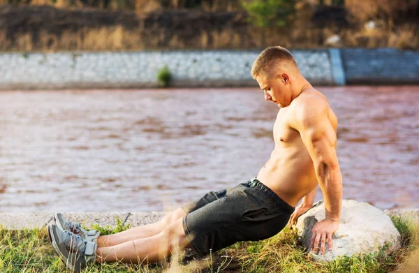Uomo che fa allenamento tricipiti vicino al fiume — Foto Stock