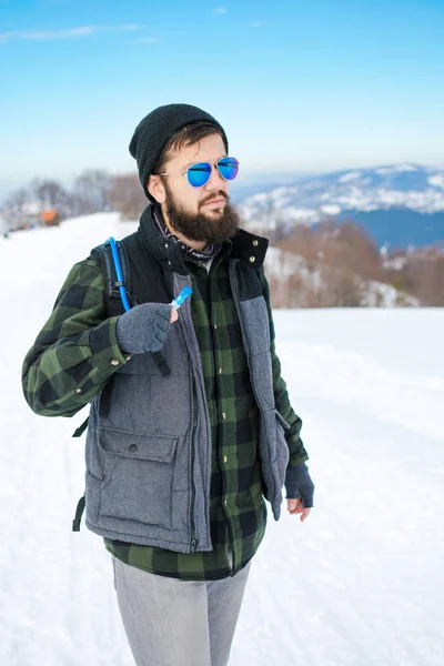 Bearded hiker walking on snow covered mountain — Stock Photo, Image