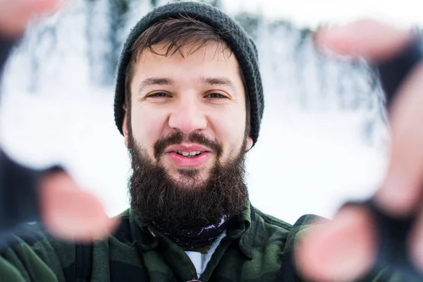 Skäggig man tar selfie på snöiga berg — Stockfoto