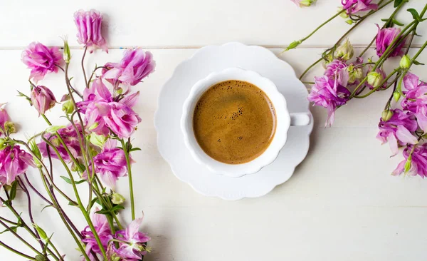 Чашка кави на столі, прикрашена квітами — стокове фото