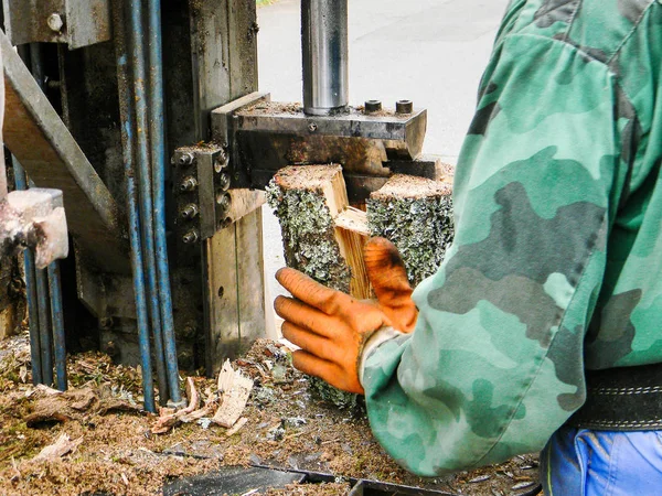 Worker chopping firewood with a machine — Stock Photo, Image