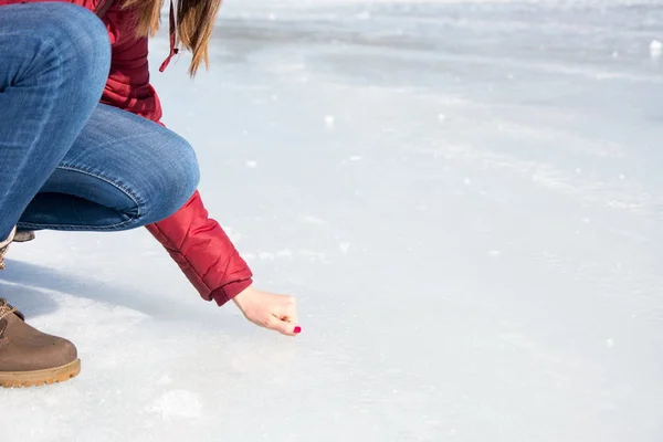 Девушка касается замерзшей поверхности озера — стоковое фото