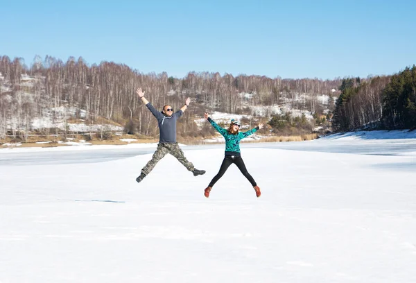 Szczęśliwy przyjaciele skoki na zamarzniętym jeziorze — Zdjęcie stockowe