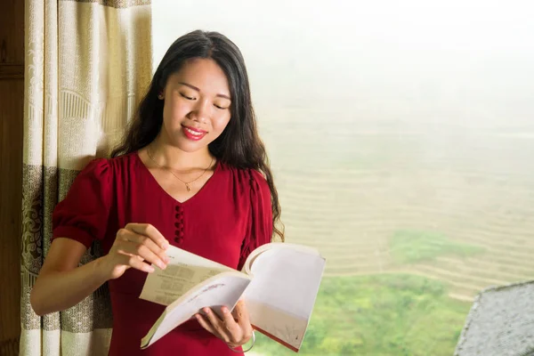 Дівчина читає книгу біля вікна з видом — стокове фото