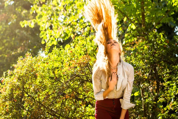 Девушка размахивает волосами в парке — стоковое фото
