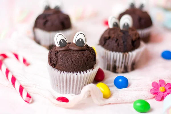 Chocolate muffins with edible eyes and colorful bonbons — Stock Photo, Image