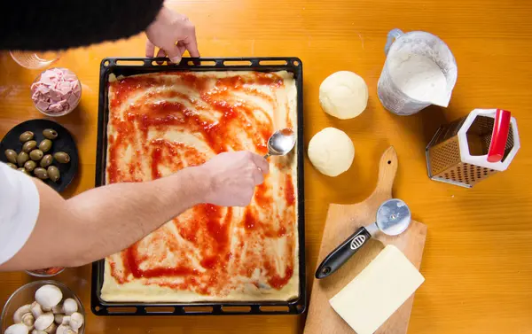 Seseorang menaruh saus tomat di piza — Stok Foto