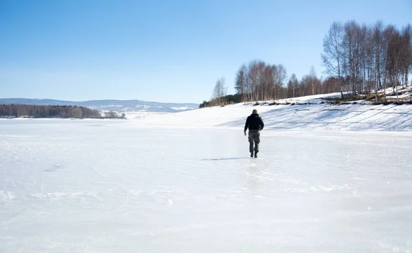 Férfi sétált a befagyott tó — Stock Fotó