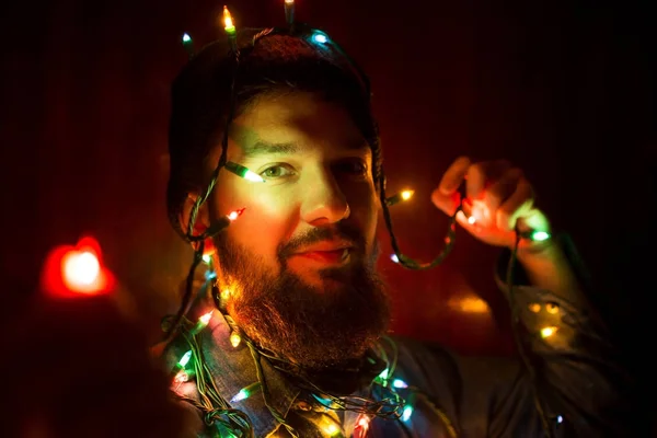 Homme barbu enveloppé dans des lumières de Noël — Photo