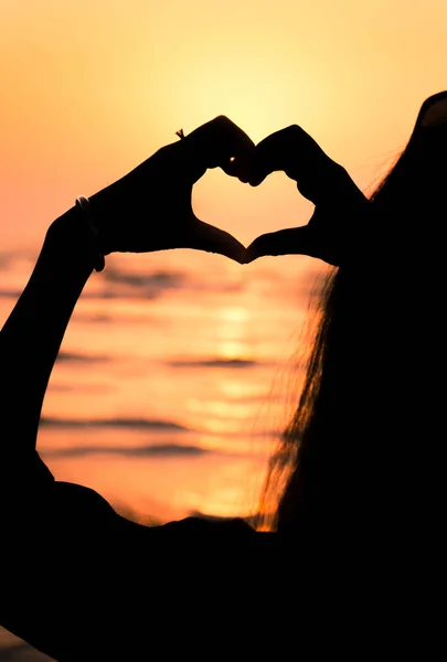 Girl making heart shape at seaside — Stock Photo, Image