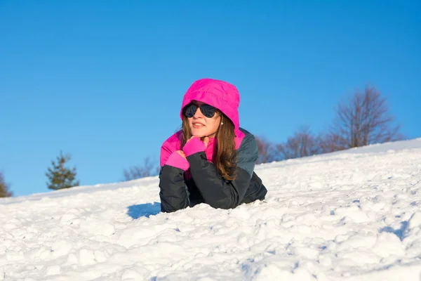 Menina que coloca na montanha coberta de neve — Fotografia de Stock