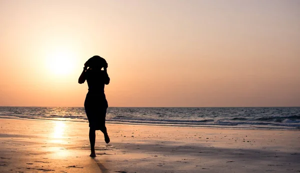 Girl on the beach at sunset — Stock Photo, Image