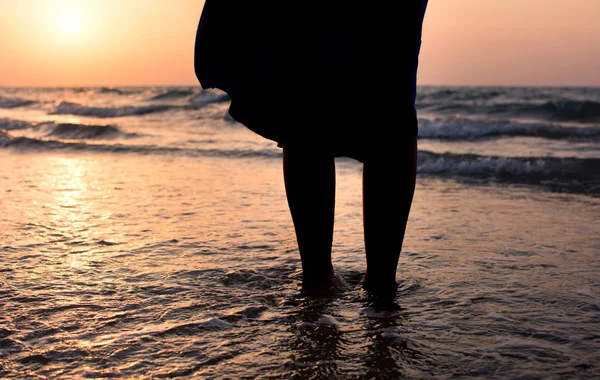 Gün batımında denize doğru yürüyen kız — Stok fotoğraf