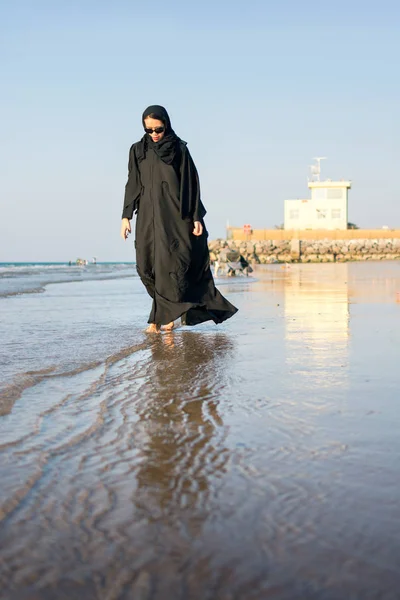 Donna in hijab a piedi sulla spiaggia — Foto Stock