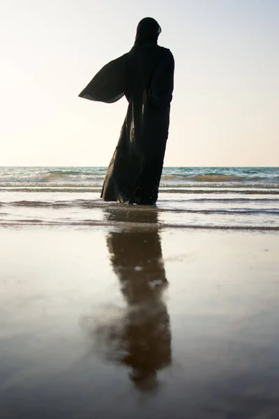 Donna in hijab in piedi sulla spiaggia — Foto Stock