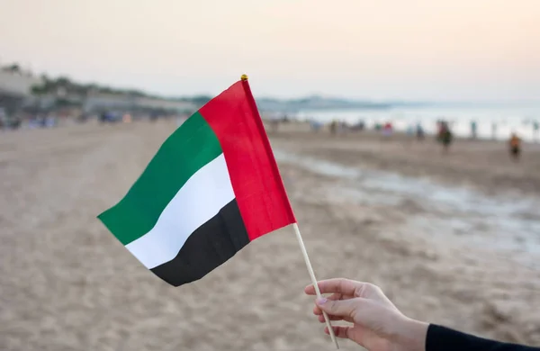 Hand vereint Arabische Emirate Flagge am Strand — Stockfoto