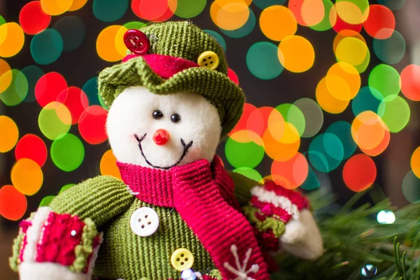 Speelgoed sneeuwpop tegen feestelijke achtergrond — Stockfoto