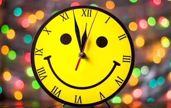 Reloj de la cara sonriente y luces de Navidad — Foto de Stock