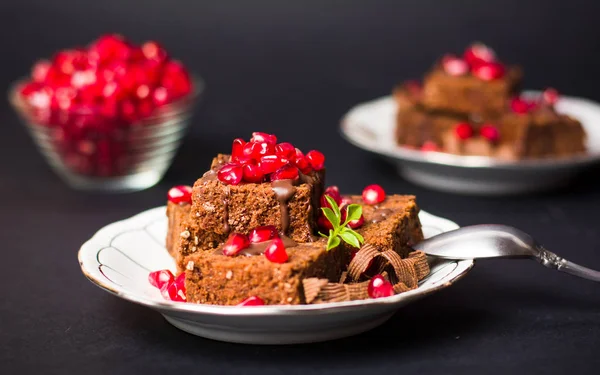 Chocolate cake with pomegranate on a plate — Stock Photo, Image