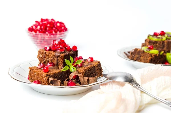 Chocolate cake with pomegranate on a plate — Stock Photo, Image