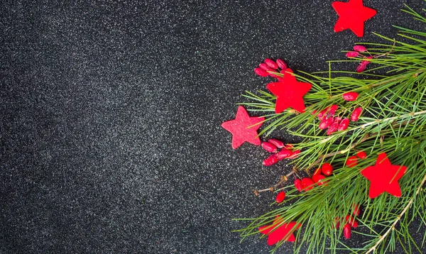 Red Christmas decorations and fir tree on dark background — Stock Photo, Image