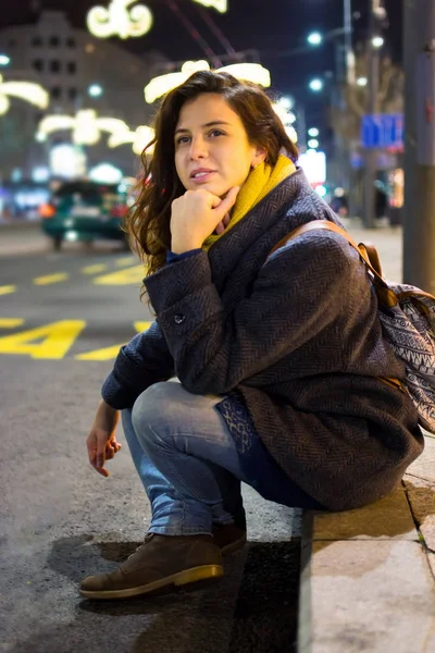 夜の道路で座っている都会の女の子 — ストック写真