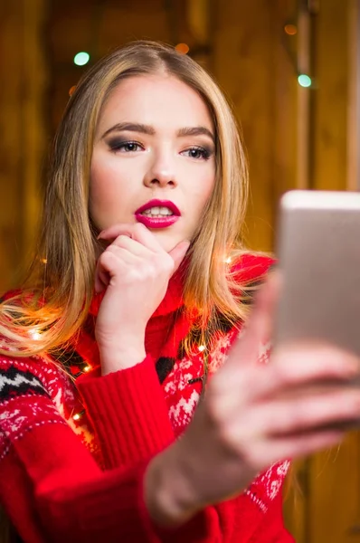 Fille prenant un selfie portant un pull rouge festif — Photo