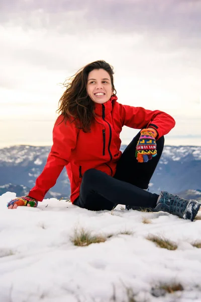 Caminhante feminino sentado no topo da montanha coberto de neve — Fotografia de Stock