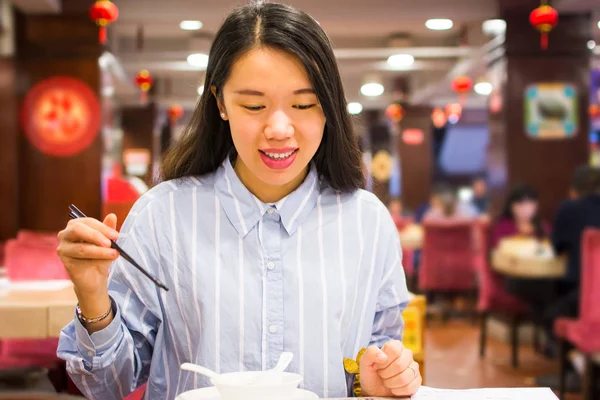 Азіатський жінка, насолоджуючись китайської кухні в китайському ресторані — стокове фото