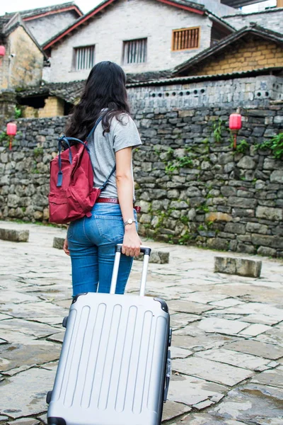 Húzza a bőröndöt, az ősi város séta lány — Stock Fotó