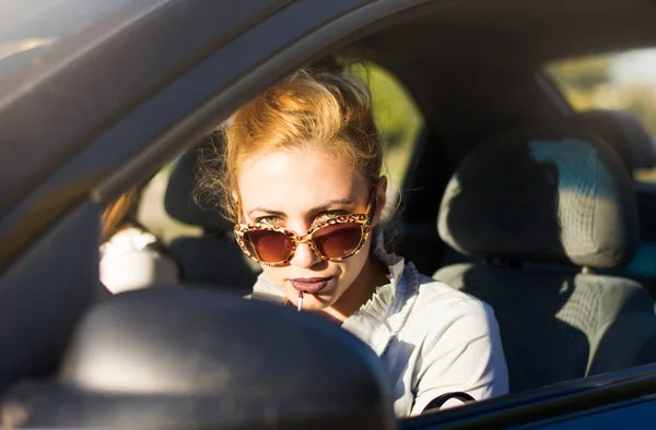 Femei șofer care aplică ruj într-o mașină — Fotografie, imagine de stoc