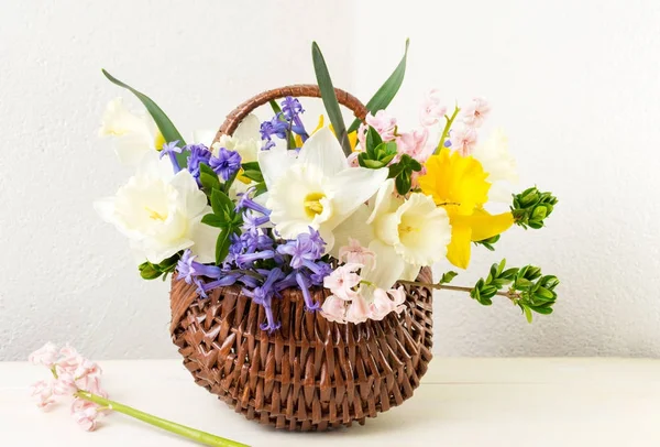 Flores de primavera coloridas em uma cesta de vime — Fotografia de Stock