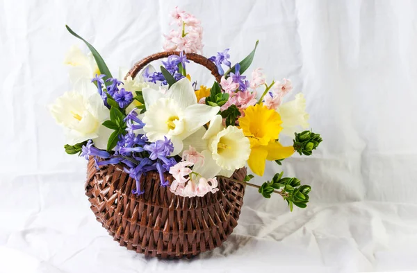 Colorful spring flowers in a wicker basket — Stock Photo, Image