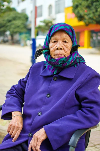 Senior asian kobieta siedzi na krześle przed domem — Zdjęcie stockowe