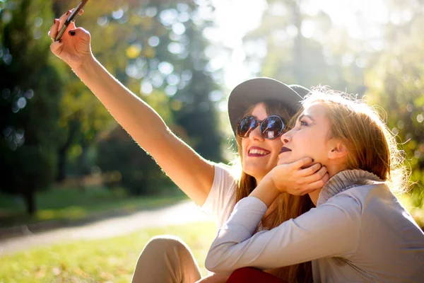 Namoradas tirando uma selfie no parque — Fotografia de Stock